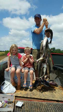 father with two daughters and string of fish